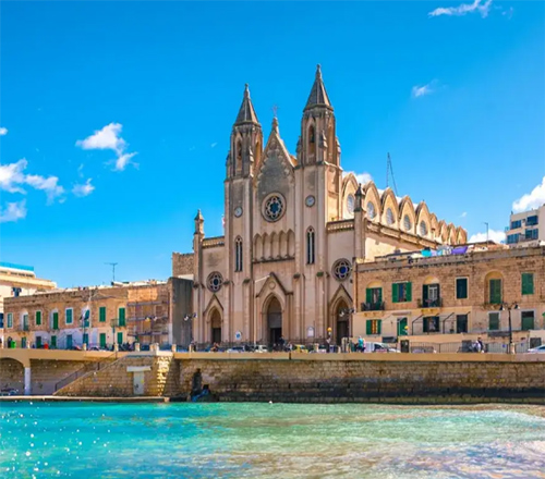 Catedral anglicana de San Pablo en La Valeta, Malta, junto al mar con edificios históricos